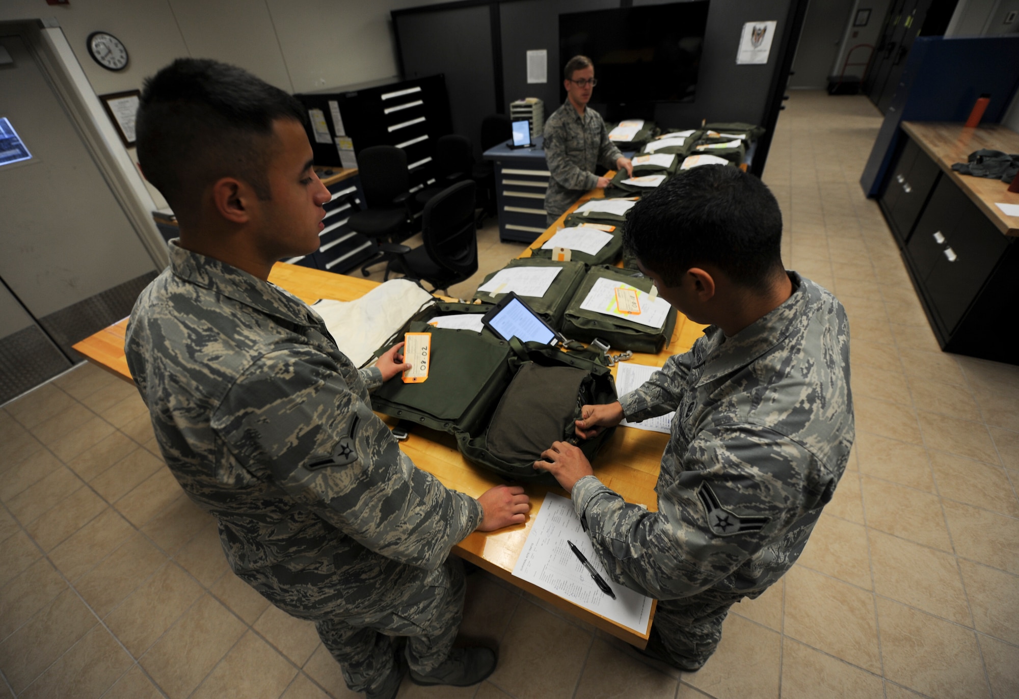 Airman 1st Class David Rodriguez and Airman Nicholas Tweet, aircrew flight equipment airmen with the 4th Special Operations Squadron, pack and inspect ML-4 survival kits at the 4th SOS AFE shop at Hurlburt Field, Fla., Dec. 4, 2015. Survival kits include items that will assist in life preserving in case of an emergency. (U.S. Air Force photo by Senior Airman Krystal M. Garrett)