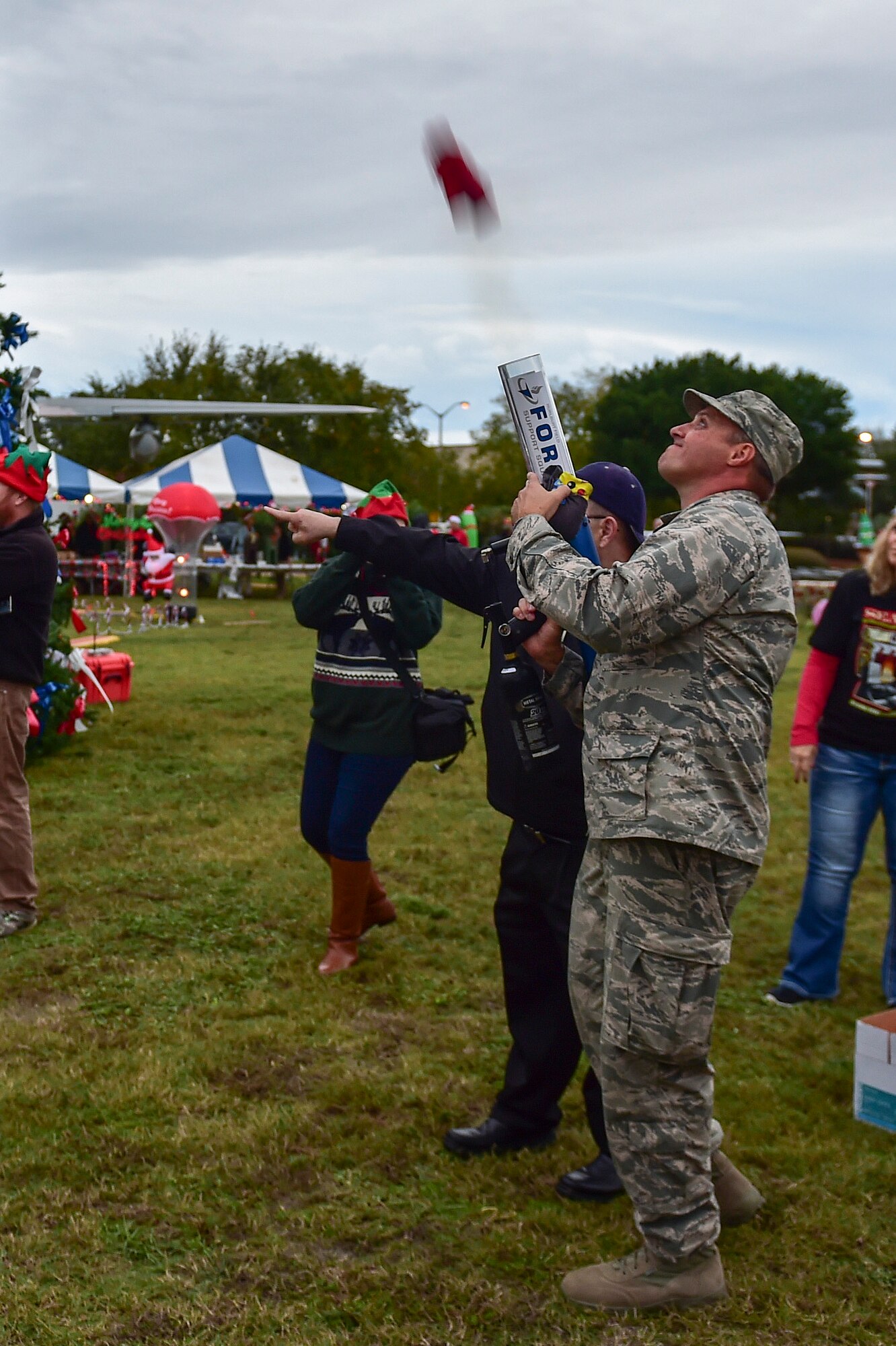 Lt. Col. Lee Comerford, commander of the 1st Special Operations Force Support Squadron, shoots a t-shirt gun during the annual Christmas tree lighting ceremony at Hurlburt Field, Fla., Dec. 2, 2015. The 1st SOFSS hosted various activities and gave away prizes during the Annual Christmas Tree Lighting and Winter Wonderland celebration. (U.S. Air Force photo by Senior Airman Jeff Parkinson)