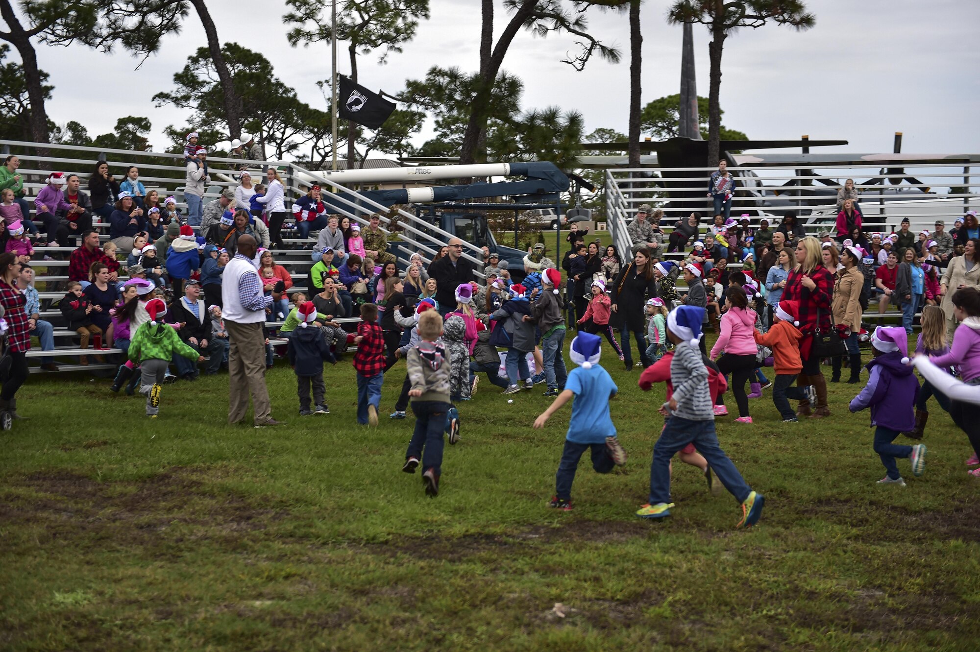 Children chase after t-shirts launched from a t-shirt gun during the annual Christmas tree lighting ceremony at Hurlburt Field, Fla., Dec. 2, 2015. The ceremony offered free food, pictures with Santa Claus and a movie in the air park. (U.S. Air Force by Senior Airman Jeff Parkinson)