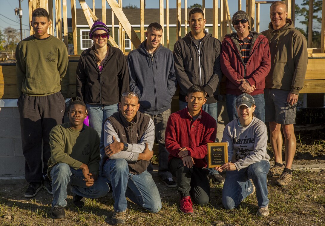 Marines with Marine Forces Reserve New Orleans pose for a picture during an award ceremony Dec. 5, 2015 at a volunteer site. The New Orleans Area Habitat for Humanity presented an award to Marine volunteers of Marine Forces Reserve in recognition of their outstanding service to the rebirth and revitalization of the city of New Orleans. Between January and Dec. 30, approximately 1,658 Marines volunteered more than 8,226 hours at 189 different volunteer events in the greater New Orleans area. 