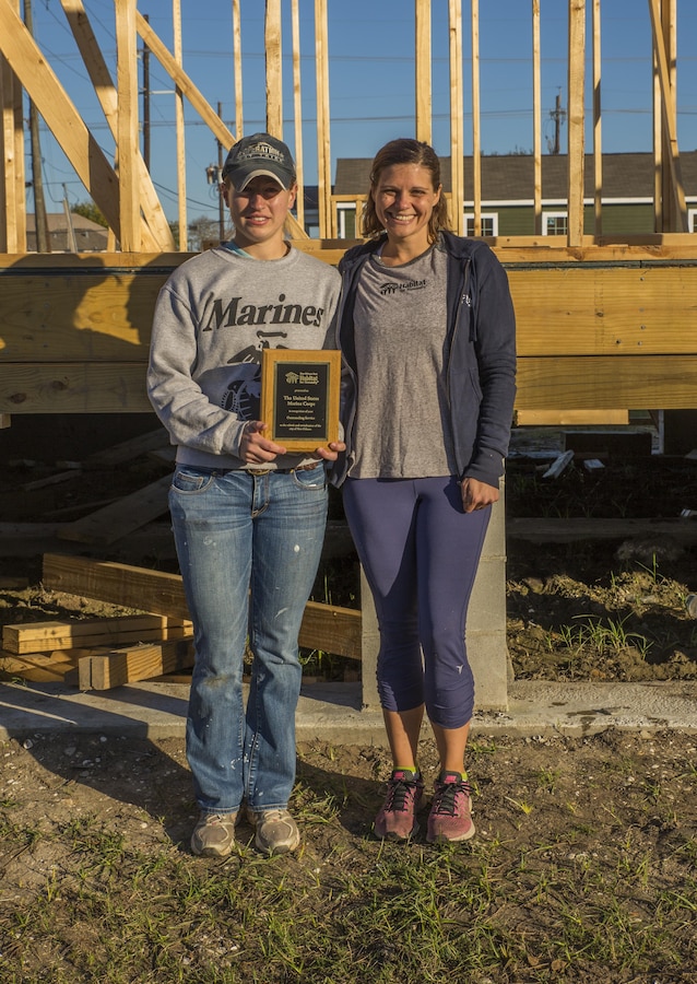 Avery Strada, (right) director of volunteer services for New Orleans Area Habitat for Humanity (left) poses for a picture with 1st Lt. Katherine Graichen (left), after she receives an award on behalf of the Marine Corps for recognition of outstanding service to the rebirth and revitalization of the city of New Orleans from Habitat for Humanity. Between January and Dec. 30, approximately 1,658 Marines volunteered more than 8,226 hours at 189 different volunteer events in the greater New Orleans area. 