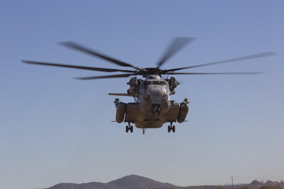 A CH-53E Super Stallion with Marine Heavy Helicopter Squadron (HMH) 361 hovers over a landing pad during Field Carrier Landing Practices aboard Marine Corps Air Station Miramar, Calif., Dec. 2. Marines with HMH-361 conducted section Confined Area Landings and Field Carrier Landing Practices to fulfill training requirements for landing aboard a Navy ship. (U.S. Marine Corps photo by Sgt. Lillian Stephens/Released)