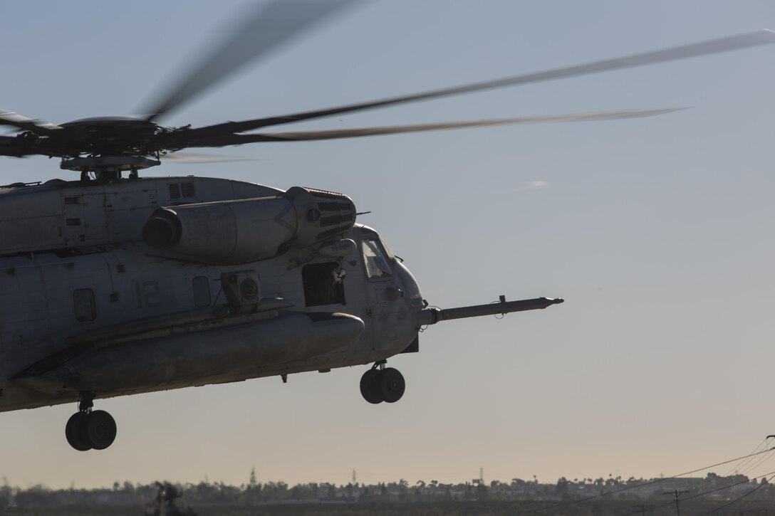 A CH-53E Super Stallion with Marine Heavy Helicopter Squadron (HMH) 361 hovers over a landing pad during Field Carrier Landing Practices aboard Marine Corps Air Station Miramar, Calif., Dec. 2. Marines with HMH-361 conducted section Confined Area Landings and Field Carrier Landing Practices to fulfill training requirements for landing aboard a Navy ship. (U.S. Marine Corps photo by Sgt. Lillian Stephens/Released)