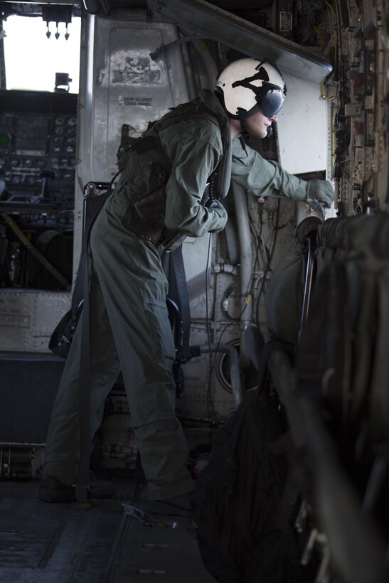 A Marine with Marine Heavy Helicopter Squadron (HMH) 361 peers out of a hatch of a CH-53E Super Stallion while flying over Marine Corps Air Station Miramar, Calif., Dec. 2. Marines with HMH-361 conducted section Confined Area Landings and Field Carrier Landing Practices to fulfill training requirements for landing aboard a Navy ship. (U.S. Marine Corps photo by Sgt. Lillian Stephens/Released)