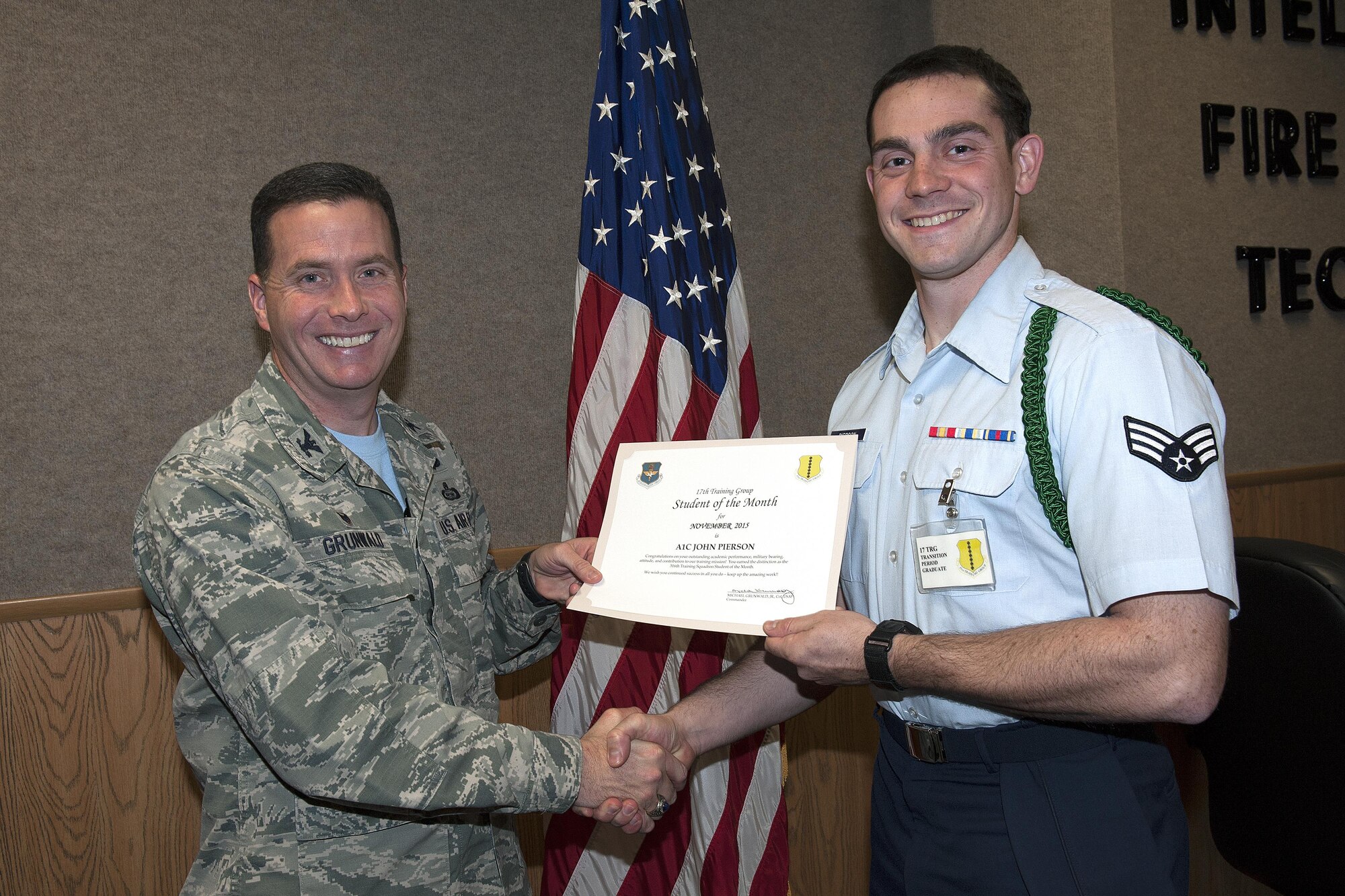U.S. Air Force Col. Michael Grunwald Jr. 17th Training Group Commander, presents the 316th Training Squadron Student of the Month award for December 2015 to Senior Airman John W. Pierson in the Brandenburg Hall on Goodfellow Air Force Base, Texas, Dec. 4, 2015. (U.S. Air Force photo by Airman 1st Class Caelynn Ferguson/Released)