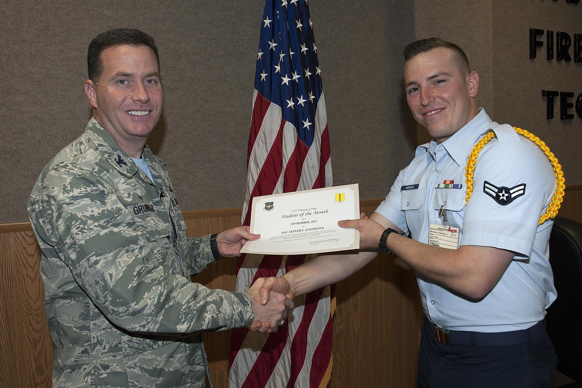 U.S. Air Force Col. Michael Grunwald Jr., 17th Training Group Commander, presents the 315th Training Squadron Student of the Month award for December 2015 to Airman 1st Class Jeffery Andrews in Brandenburg Hall on Goodfellow Air Force Base, Texas, Dec. 4, 2015. (U.S. Air Force photo by Airman Caelynn Ferguson/Released)