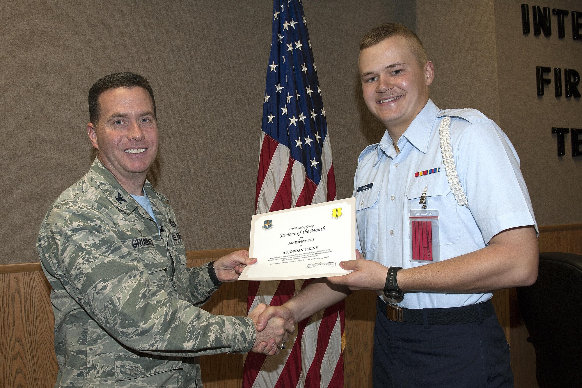 U.S Air Force Col. Michael Grunwald Jr., 17th Training Group Commander, presents the 312th Training Squadron Student of the Month award for December 2015 to Airman Jordan Elkins in Brandenburg Hall on Goodfellow Air Force Base, Texas, Dec. 4, 2015. (U.S. Air Force photo by Airman Caelynn Ferguson/Released)