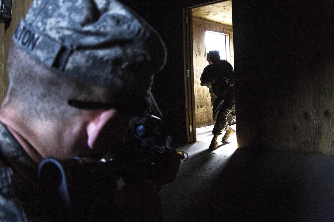 A soldier prepares to "ambush" two other soldiers entering a room during training at the Urban Assault Course on Fort Jackson, S.C., Dec. 3, 2015. U.S. Army photo by Sgt. 1st Class Brian Hamilton