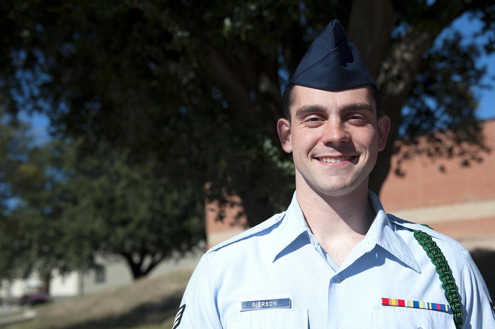 U.S. Air Force Senior Airman John W. Pierson, 316th Training Squadron intel student, smiles for a portrait in front of Brandenburg Hall on Goodfellow Air Force Base, Texas, Dec. 4, 2015. Pierson received the Student of the Month award for his dedication and service. (U.S. Air Force photo by Airman 1st Class Caelynn Ferguson/Released)
