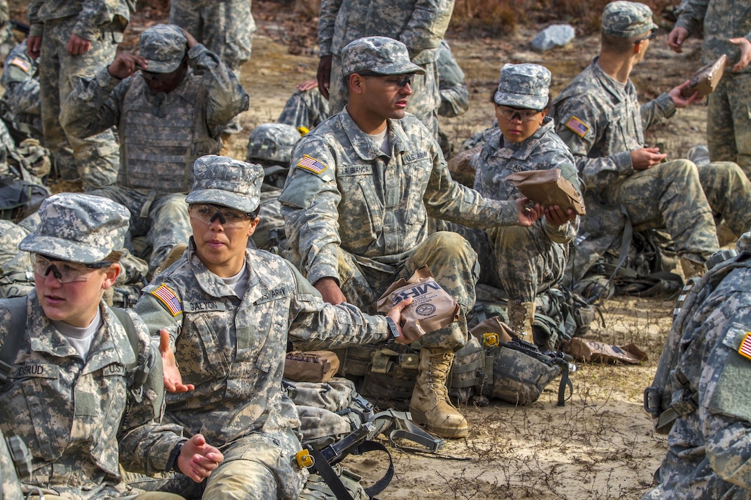 Soldiers pass along some meals ready to eat to their battle buddies during a lunch break at the Urban Assault Course on Fort Jackson, S.C., Dec. 3, 2015. U.S. Army photo by Sgt. 1st Class Brian Hamilton 