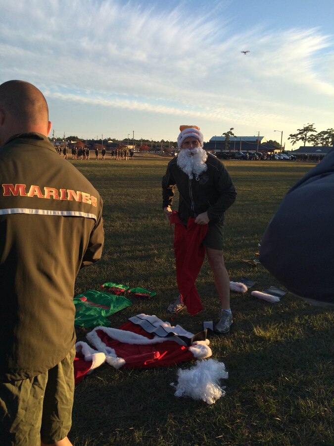 As part of the Holiday Fun Run at Courthouse Bay, Camp Lejeune, N.C. on Dec. 4, 2015; Marines of Marine Corps Engineer School competed in the Commanding Officer's Holiday Sleigh Relay Race in which teams of Marines from each company constructed a sleigh with provided materials, company commanders, company first sergeants and Marines donned costumes; and then the teams raced across the parade field.  LtCol Taylor P. White dons a Santa suit as part of the relay race. 
