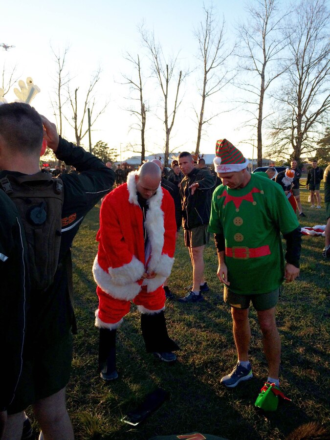 As part of the Holiday Fun Run at Courthouse Bay, Camp Lejeune, N.C. on Dec. 4, 2015; Marines of Marine Corps Engineer School competed in the Commanding Officer's Holiday Sleigh Relay Race in which teams of Marines from each company constructed a sleigh with provided materials, company commanders, company first sergeants and Marines donned costumes; and then the teams raced across the parade field.  Major Kirk A. Whittenberg dons a Santa suit and First Sergeant Douglas M. Hester dons an elf costume as part of the relay race.
