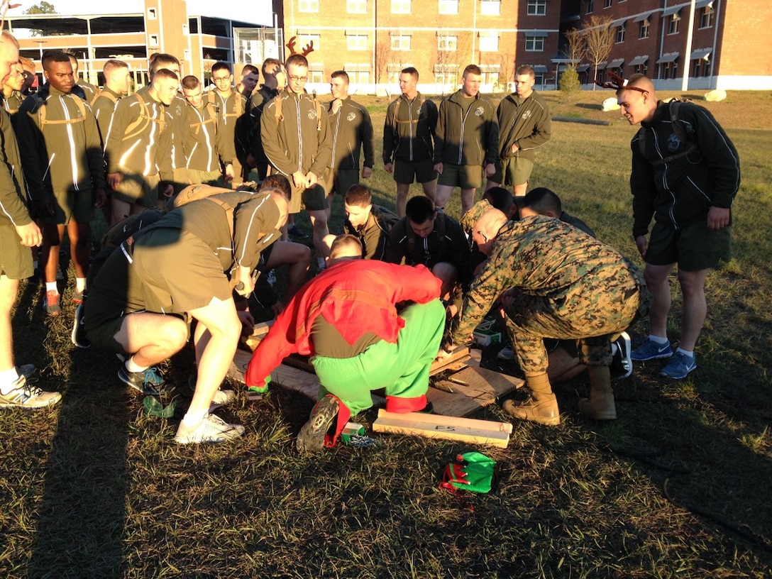 As part of the Holiday Fun Run at Courthouse Bay, Camp Lejeune, N.C. on Dec. 4, 2015; Marines of Marine Corps Engineer School competed in the Commanding Officer's Holiday Sleigh Relay Race in which teams of Marines from each company constructed a sleigh with provided materials, company commanders, company first sergeants and Marines donned costumes; and then the teams raced across the parade field.  Marines from Headquarters and Service Company lay out the sleigh materials prior to construction.    