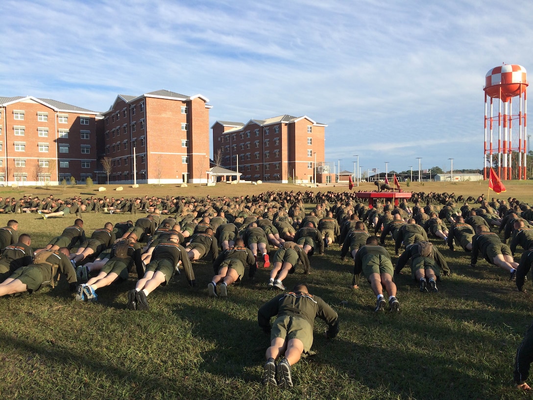 Marines from Marine Corps Engineer School (MCES) perform Marine Corps push-ups as part of a group of warm-up exercises prior to the MCES Holiday Fun Run on Dec. 4, 2015 at Courthouse Bay, Camp Lejeune, N.C.
