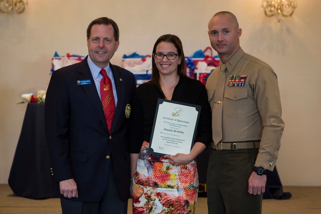 The 2015 San Diego Sea Service Marine Corps Spouse of the Year recipient, Amanda McMillan, poses with her husband, Chief Warrant Officer Christopher McMillan, after being awarded at the San Diego Council Navy League monthly luncheon in San Diego, Dec. 4.  As a I Marine Expeditionary Force spouse, Amanda was awarded for her dedication to educating and volunteering with groups such as special needs children and fellow military families. The award was presented to McMillan by Jon Berg-Johnson (left), council president of San Diego Council Navy League of the United States. This is the fifth consecutive year a I MEF spouse has won the award. Nominees were selected by their respective commands for exhibiting a balance in their military community, their work and home life, and for serving their local community. Both Amanda and Christopher are Zephyrhills, Florida, natives. Christopher is a bulk fuel officer with 7th Engineer Support Battalion, 1st Marine Logistics Group, I MEF. “I’m more than honored to receive the award, but I know I could have done, can do so much more for the community. I can never express how thankful I am for the serves the military has provided me and my family,” Amanda said.