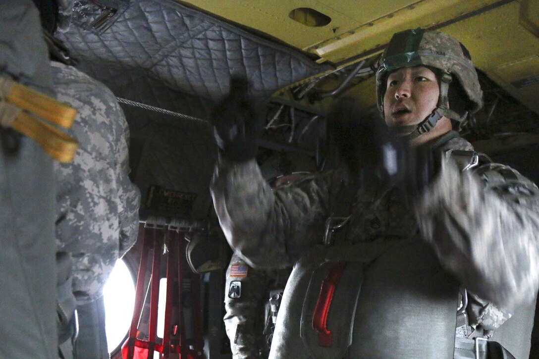 Army Staff Sgt. Brian Kim gives the command for paratroopers to hook-up during an airborne operation over Malamute drop zone, Joint Base Elmendorf-Richardson, Alaska, Dec. 3, 2015. Kim is a squad leader assigned to the 25th Infantry Division’s 3rd Battalion, 509th Infantry Regiment, 4th Infantry Brigade Combat Team, Airborne, Alaska. U.S. Army photo by Staff Sgt. Brian Ragin