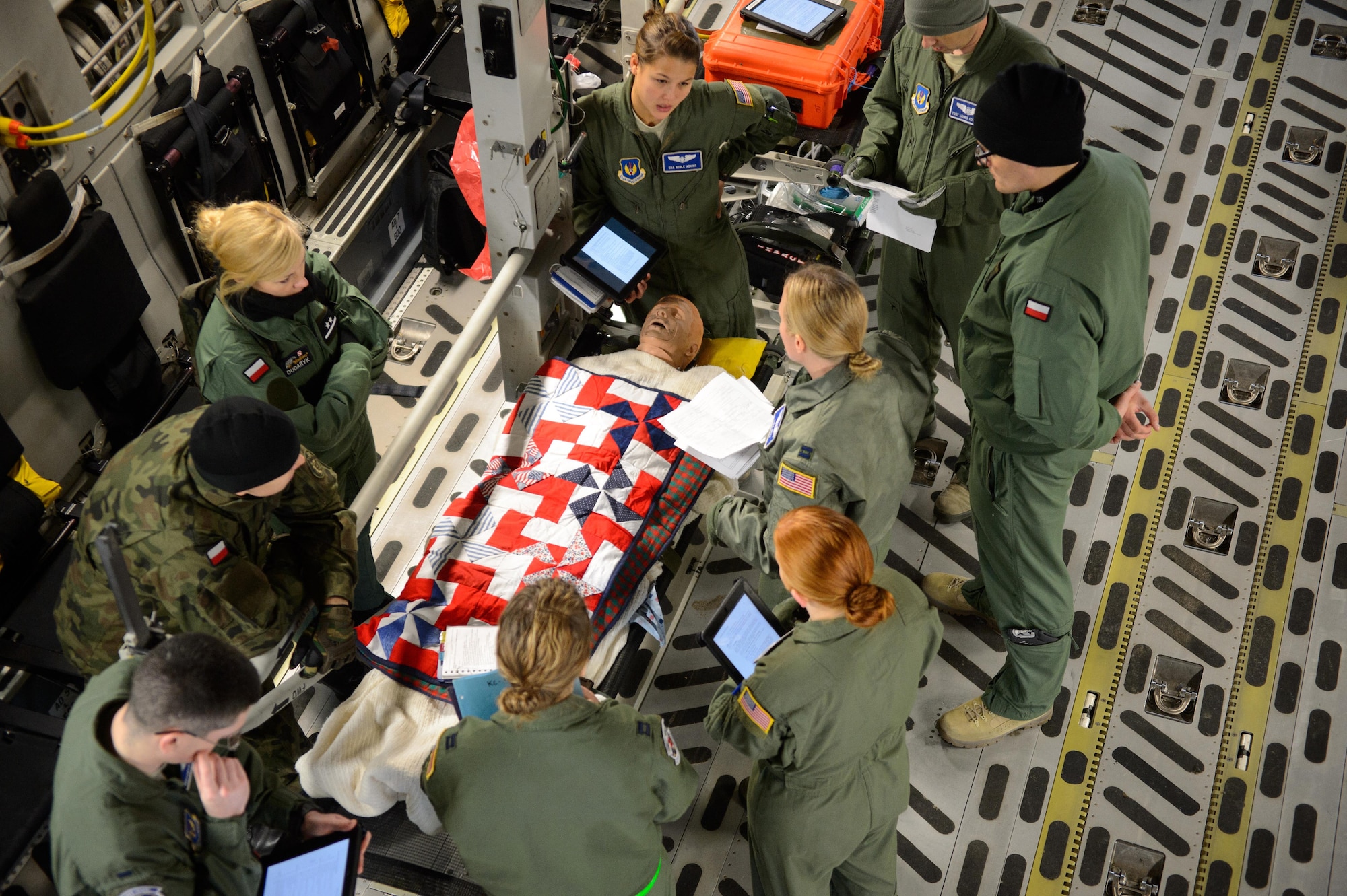 Members from the 86th Aeromedical Evacuation Squadron and Polish aeromedical evacuation specialists discuss the proper treatment of a mock patient Dec. 3, 2015, at Ramstein Air Base, Germany. Members of the 86th AES showcased their skills for the Polish medical officials in order for them to adapt desired skills. (U.S. Air Force photo/Staff Sgt. Armando A. Schwier-Morales)