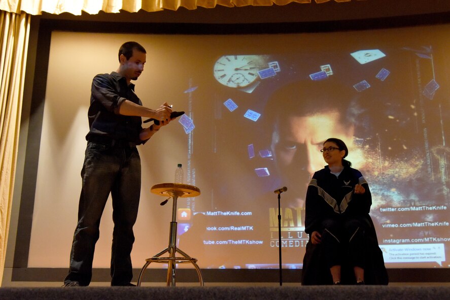 Matt the Knife, magician and mentalist, holds a lighter near a voodoo doll during a trick at the theater on Goodfellow Air Force Base, Texas, Dec. 4, 2015. Once Matt was done with the lighter, he made the Airman open her hand to reveal a black ash-like mark. (U.S. Air Force photo by Senior Airman Joshua Edwards/Released)