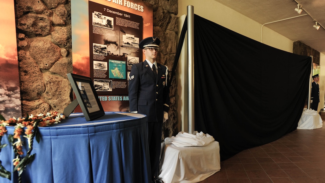 U.S. Air Force Airmen with the 15th Wing Honor Guard wait to lower the curtain covering "Old Glory" during a ceremony, Dec. 7, 2015, Joint Base Pearl Harbor-Hickam, Hawaii. The ceremony was held to unveil the new flag case "Old Glory" is to be displayed in. (U.S. Air Force photo by Tech. Sgt. Amanda Dick/Released)
