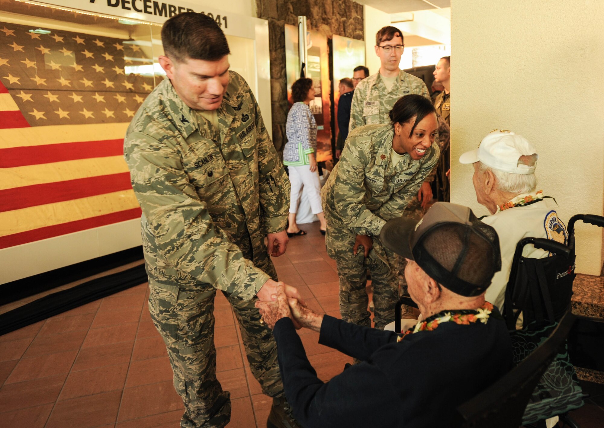 U.S. Air Force Airmen with Pacific Air Forces greet former U.S. Army Air Forces Tech. Sgt. Durward Swanson and retired U.S. Air Force Col. Andrew Kowalski, Hickam Field attack survivors, after a ceremony, Dec. 7, 2015, Joint Base Pearl Harbor-Hickam, Hawaii. The ceremony was held to unveil the new flag case "Old Glory" is to be displayed in. (U.S. Air Force photo by Tech. Sgt. Amanda Dick/Released)