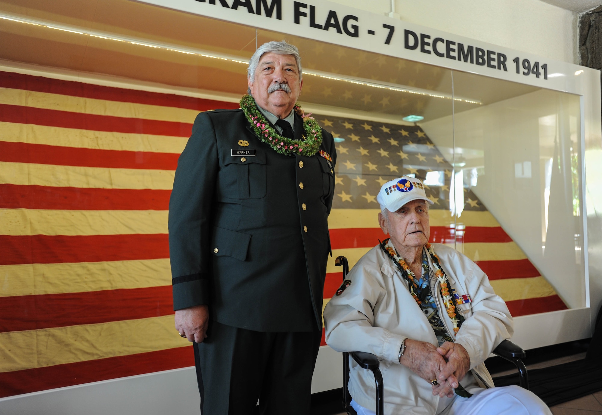 (Left to right) Retired U.S. Army Maj. Wynn Warner and former U.S. Army Air Forces Tech. Sgt. Durward Swanson, Hickam Field attack survior, take a photo with "Old Glory" after a ceremony, Dec. 7, 2015, Joint Base Pearl Harbor-Hickam, Hawaii. Warner’s father, U.S. Army Air Forces Sgt. Tracy Warner, raised the flag Dec. 7, 1941, and Swanson lowered it the night after the attacks. (U.S. Air Force photo by Tech. Sgt. Amanda Dick/Released)