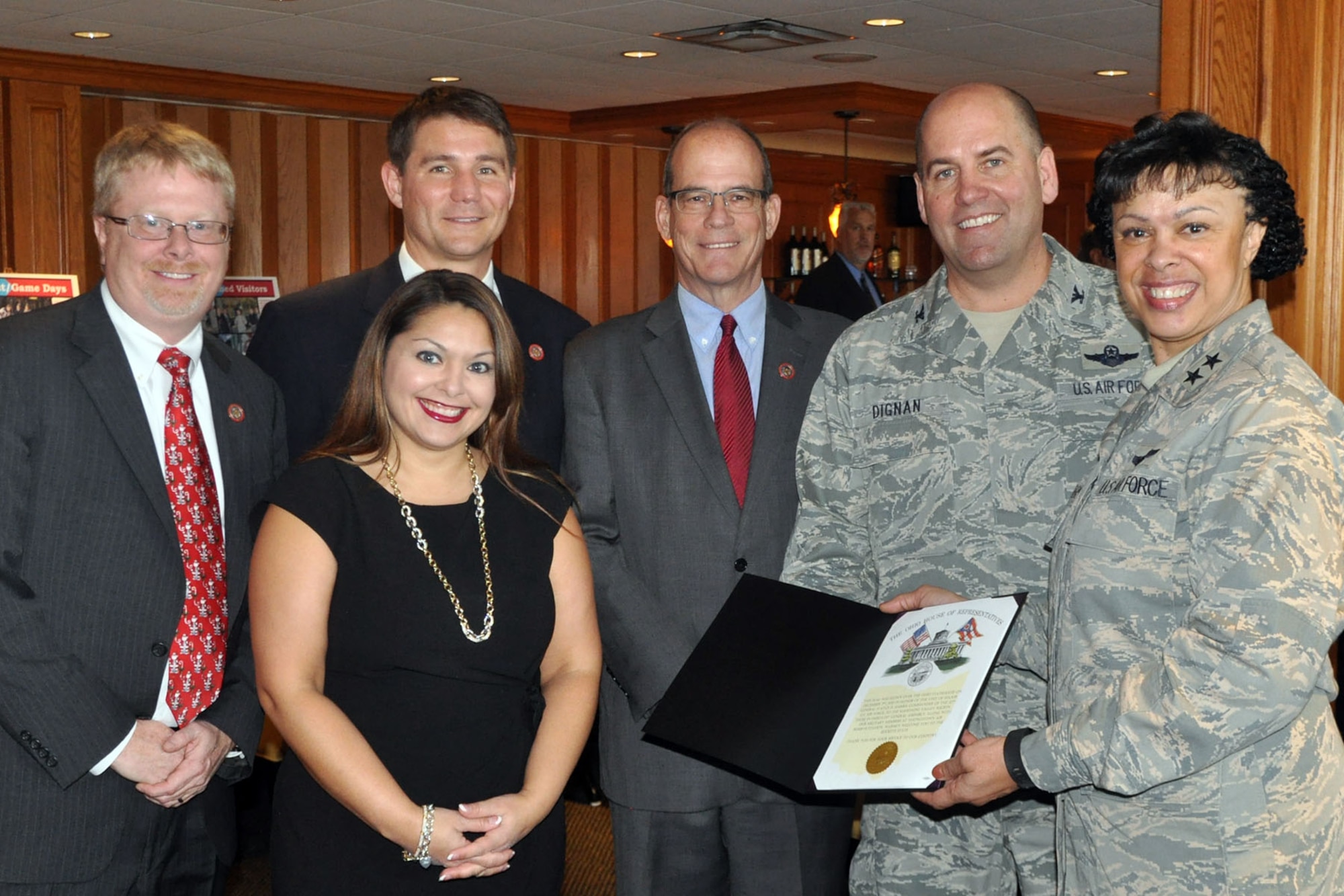 Air Force Reserve 22nd Air Force commander Maj. Gen. Stayce Harris (right) and Col. James Dignan, 910th Airlift Wing commander, stand with members of the Ohio State House of Representatives Mahoning Valley delegation during a Community Welcome Luncheon held at Squaw Creek Country Club here, Dec. 4, 2015. The state legislators, including 63rd District Representative Sean O’ Brien (left), 32nd District Senator Capri Cafaro (front), 59th District Representative John Boccieri (rear) and 64th District Representative Michael O’Brien (center) presented Harris with an state of Ohio pennant and an accompanying certificate as part of the festivities welcoming the general to the Mahoning Valley during her visit to nearby Youngstown Air Reserve Station (YARS), Ohio. Harris visited YARS to get an up close look at the 910th’s mission capabilities including the Department of Defense’s only large-area, fixed wing aerial spray mission and the roles more than 1800 personnel assigned to YARS have in national defense. (U.S. Air Force photo/Master Sgt. Bob Barko Jr.)