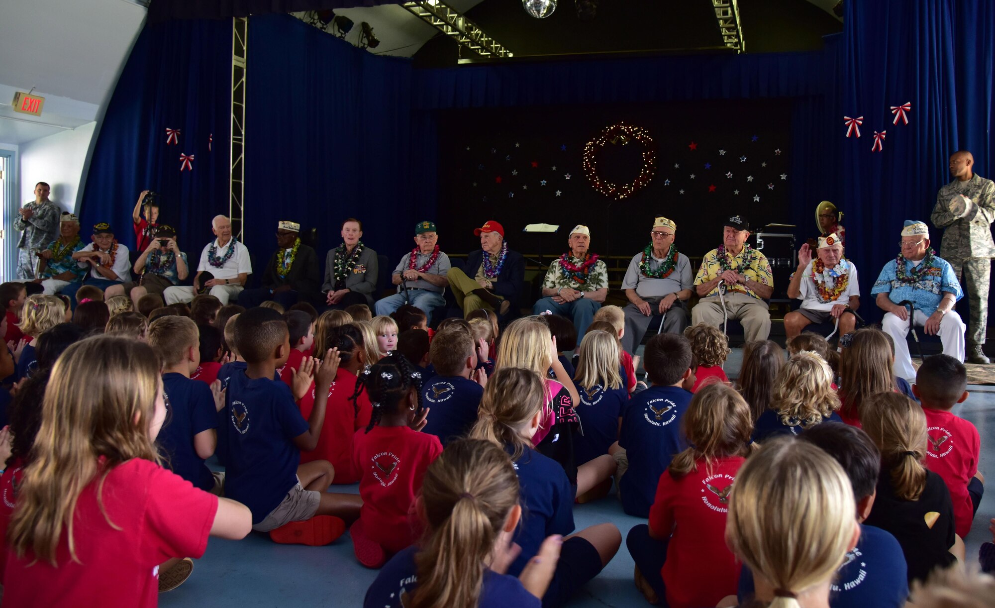Members of the Pearl Harbor Survivor's Association wait for choral performances to begin during their visit to Hickam Elementary, Dec. 3, 2015, here on Joint Base Pearl Harbor-Hickam.During the visit, the survivors provided stories to students and faculty, enjoyed a school lunch and were treated to a choral performance by the school's music department. (U.S. Air Force photo by Staff Sgt. Christopher Stoltz/Released)