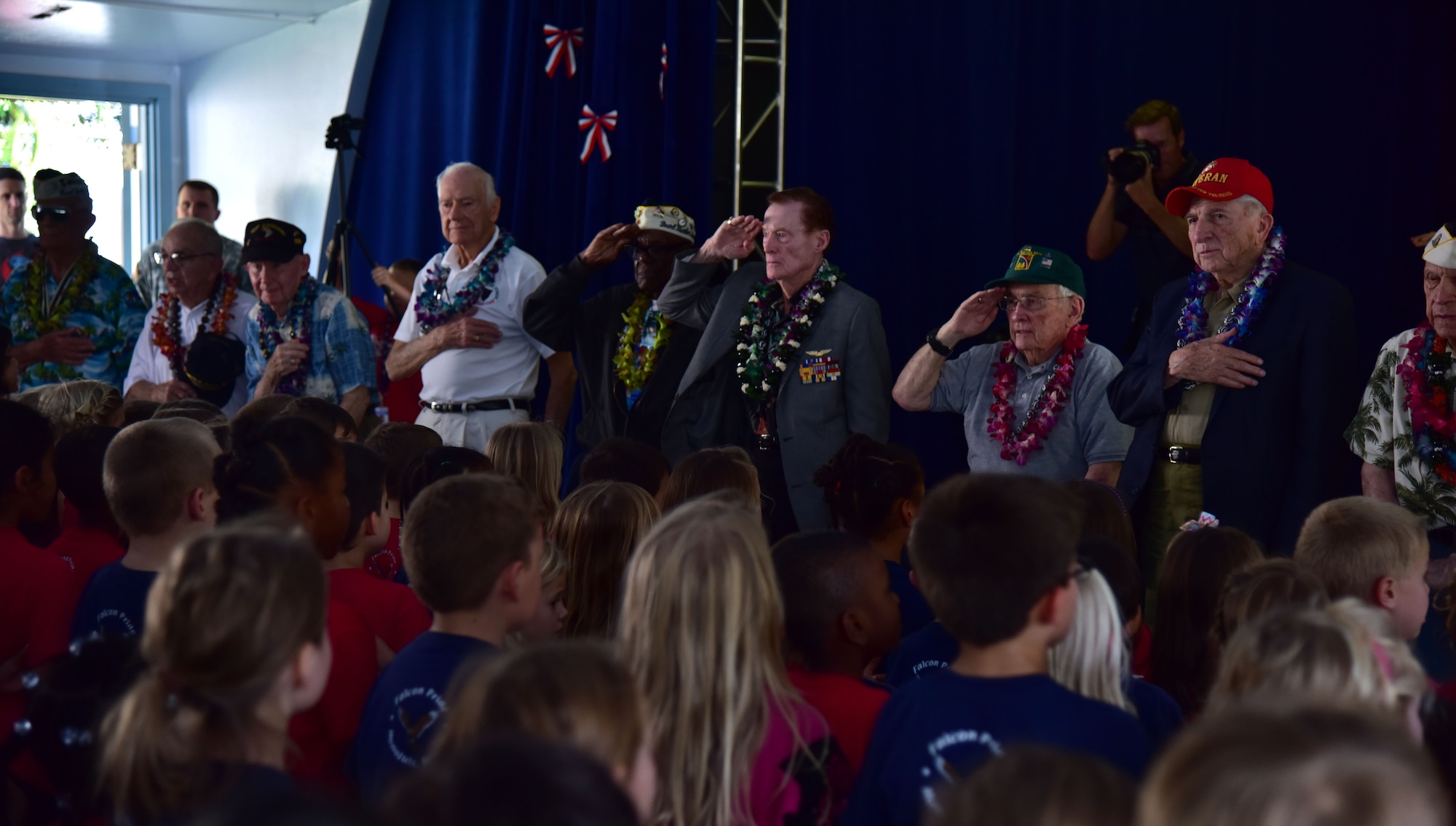 Members of the Pearl Harbor Survivor's Association stand at attention during the pledge of allegiance during their visit to Hickam Elementary, Dec. 3, 2015, here on Joint Base Pearl Harbor-Hickam. During the visit, the survivors provided stories to students and faculty, enjoyed a school lunch and were treated to a choral performance by the school's music department. (U.S. Air Force photo by Staff Sgt. Christopher Stoltz/Released)