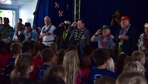 Members of the Pearl Harbor Survivor's Association stand at attention during the pledge of allegiance during their visit to Hickam Elementary, Dec. 3, 2015, here on Joint Base Pearl Harbor-Hickam. During the visit, the survivors provided stories to students and faculty, enjoyed a school lunch and were treated to a choral performance by the school's music department. (U.S. Air Force photo by Staff Sgt. Christopher Stoltz/Released)