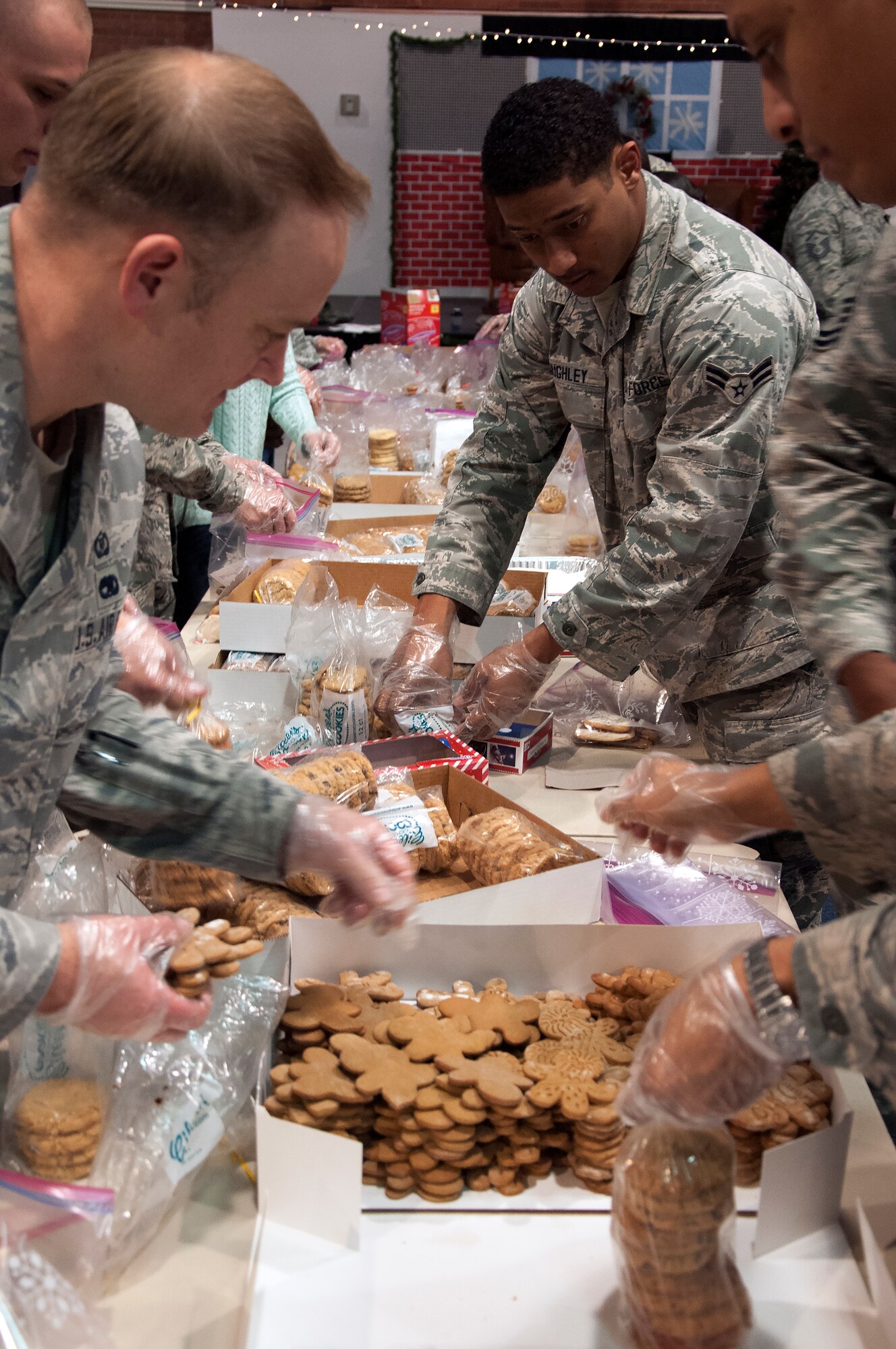 Volunteers make cookie bags for Airmen living in the dorms Dec. 7, 2015, inside the Fall Hall Community Center on F.E. Warren Air Force Base, Wyo. More than 40 volunteers came together to help spread a little holiday cheer to the dorm residents. (U.S. Air Force photo by Senior Airman Brandon Valle)