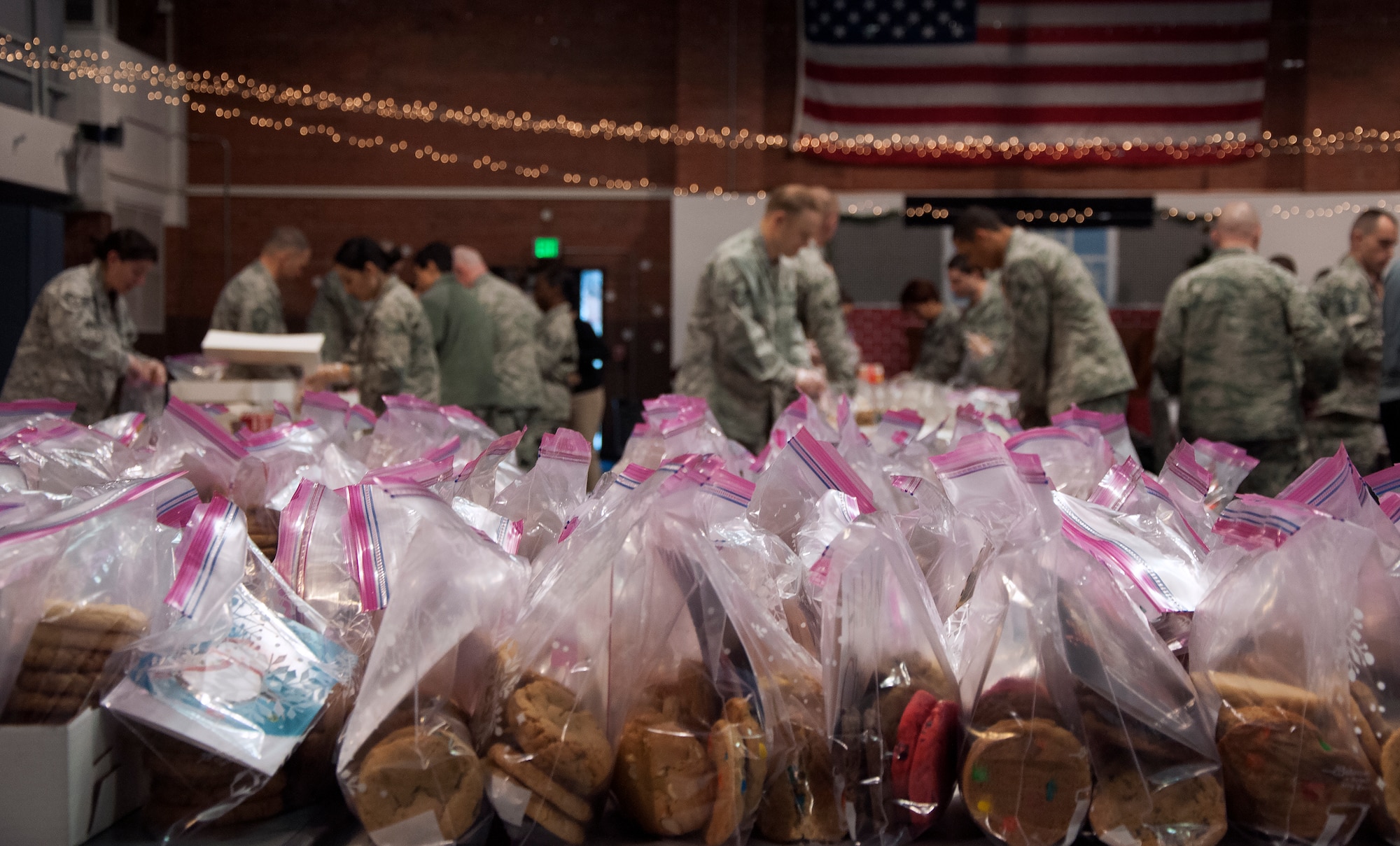 Volunteers organize more than 6,000 cookies into 500 cookie bags Dec. 7, 2015, inside the Fall Hall Community Center on F.E. Warren Air Force Base, Wyo. Each bag was delivered to the rooms of Airmen living in the dorms. (U.S. Air Force photo by Senior Airman Brandon Valle)