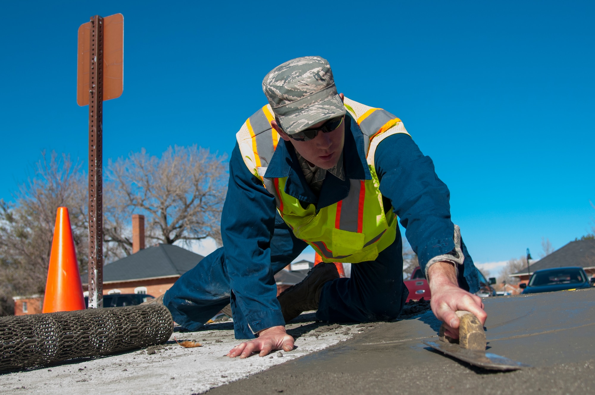 Staff Sgt. Justin Morrison, 90th Civil Engineer Squadron Pavements and Equipment, smooth’s out concrete poured outside the Chadwell Dining Facility on F.E. Warren Air Force Base, Wyo., Nov. 10, 2015. The concrete replaced gravel that pedestrians often kicked into the roads, posing wear and tear issues for the road. (U.S. Air Force photo by Senior Airman Jason Wiese)