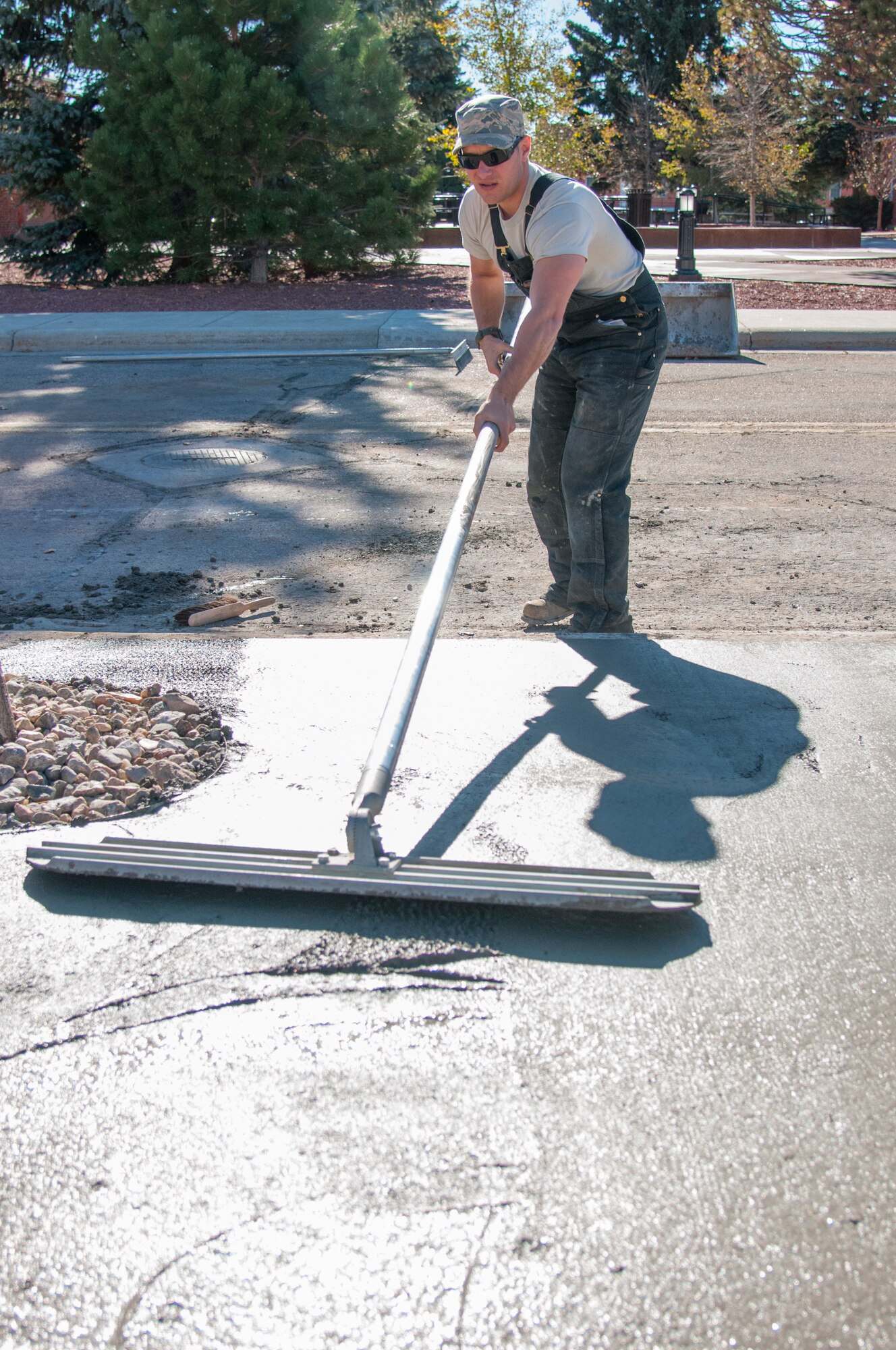 Tech. Sgt. Mike Rich, 90th Civil Engineer Squadron Pavements and Equipment, uses a bull float to smooth out large sections of newly poured concrete outside the Chadwell Dining Facility on F.E. Warren Air Force Base, Wyo., Nov. 10, 2015. 90th CES Airmen complete a wide range of maintenance and construction projects each year. (U.S. Air Force photo by Senior Airman Jason Wiese)