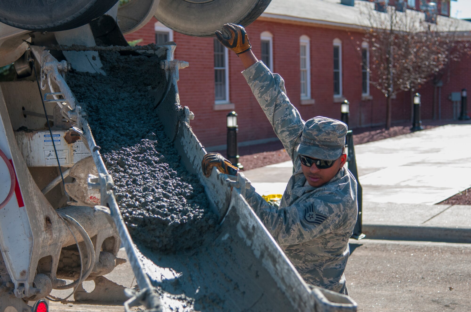 Staff Sgt. David Vaughner, 90th Civil Engineer Squadron Heavy Equipment, guides the concrete pouring outside along the road outside the Chadwell Dining Facility on F.E. Warren Air Force Base, Wyo., Nov. 10, 2015. CE Airmen perform maintenance on roads, interior lighting, heating, ventilation, air conditioning and other projects on base. (U.S. Air Force photo by Senior Airman Jason Wiese)