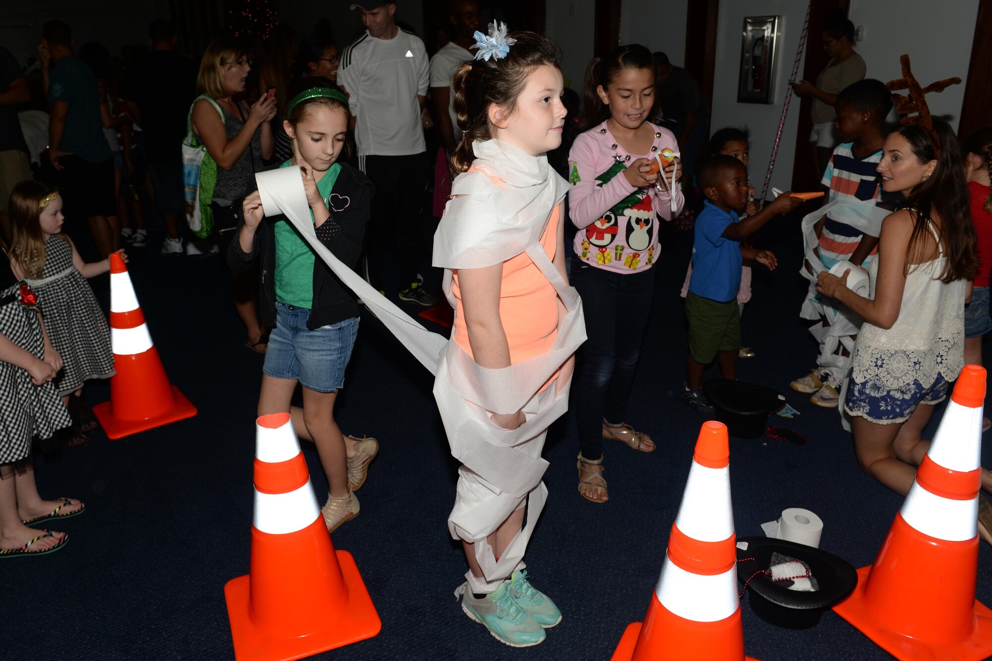 An Andersen student is wrapped in toilet paper as part of a snowman-making contest during the children’s holiday party Dec. 5, 2015, at Andersen Air Force Base, Guam. Children partook in activities including ring toss, snowman costume building and a coloring contest. (U.S. Air Force photo/Airman 1st Class Alexa Ann Henderson) 