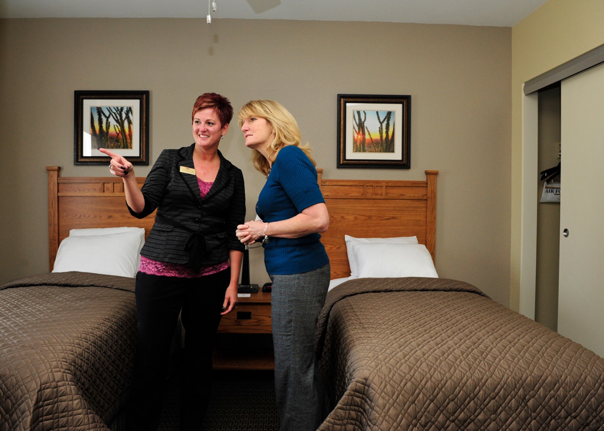 Jane Yates, 56th Force Support Squadron lodging manager, provides Cheryl Roberson, wife of Lt. Gen. Darryl Roberson, commander of Air Education and Training Command, a walkthrough of a two-bedroom lodging unit inside the newly built Temporary Lodging Facility Dec. 3, 2015, at Luke Air Force Base, Ariz. The new TLF has 30 rooms available, including pet friendly rooms. (U.S. Air Force photo by Senior Airman Grace Lee)