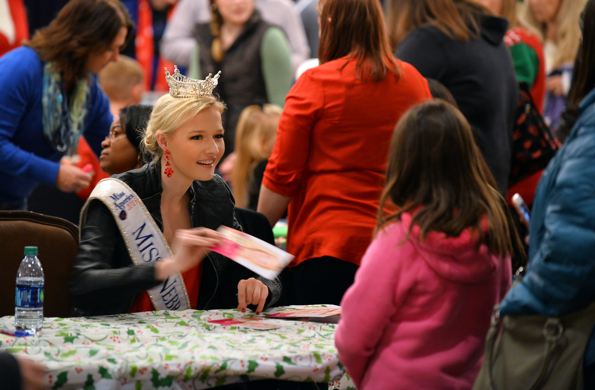 Alyssa Howell, Miss Nebraska, greets people attending the annual Christmas Tree Lighting ceremony hosted at the Patriot Club on Dec. 3, Offutt Air Force Base, Neb.  Howell signed autographs and took photos with numerous children at the ceremony.  (U.S. Air Force photo by Josh Plueger/Released)