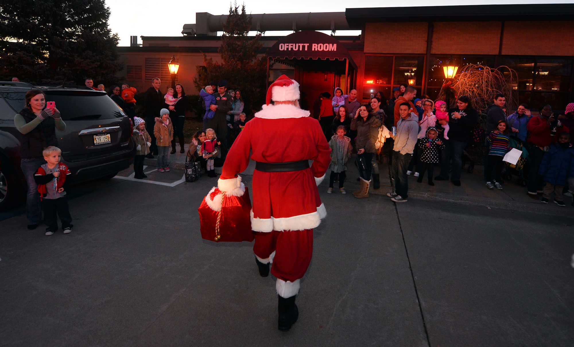 Santa Claus makes his way to the Patriot Club to the delight of families waiting in line to attend the annual Christmas Tree Lighting ceremony on Dec. 3, Offutt Air Force Base, Neb.  Mr. and Mrs. Claus welcome the hundreds of kids who attend the ceremony made possible by the 55th Force Support Squadron.  (U.S. Air Force photo by Josh Plueger/Released)