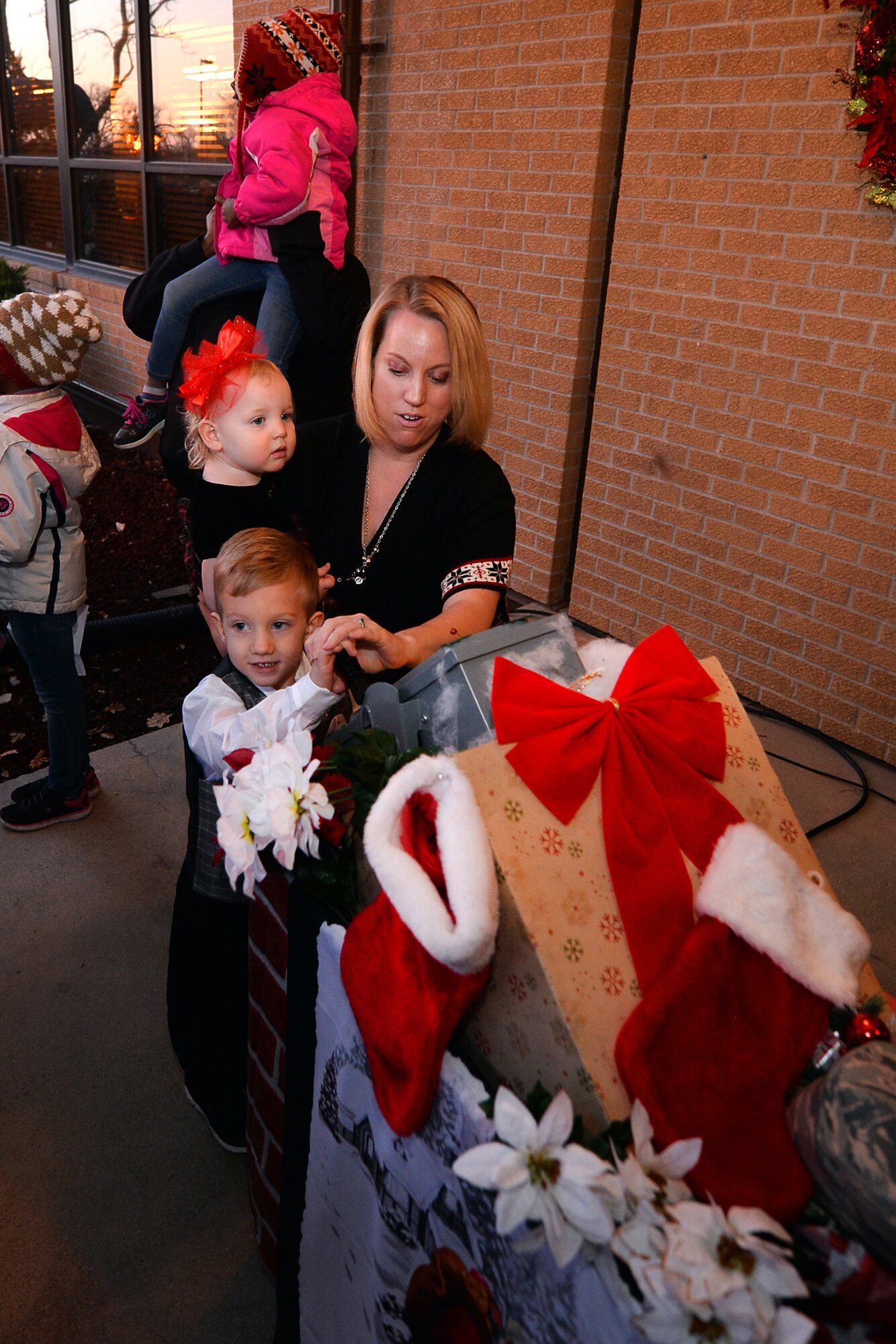 Members of the Steinke family ceremoniously flip the switch to illuminate the Christmas tree during the annual Christmas Tree Lighting ceremony held at the Patriot Club on Dec. 3, Offutt Air Force Base, Neb.  The Steinke family is without their husband and father, U.S. Air Force Master Sgt. Hans Steinke, who his currently deployed.  (U.S. Air Force photo by Josh Plueger/Released