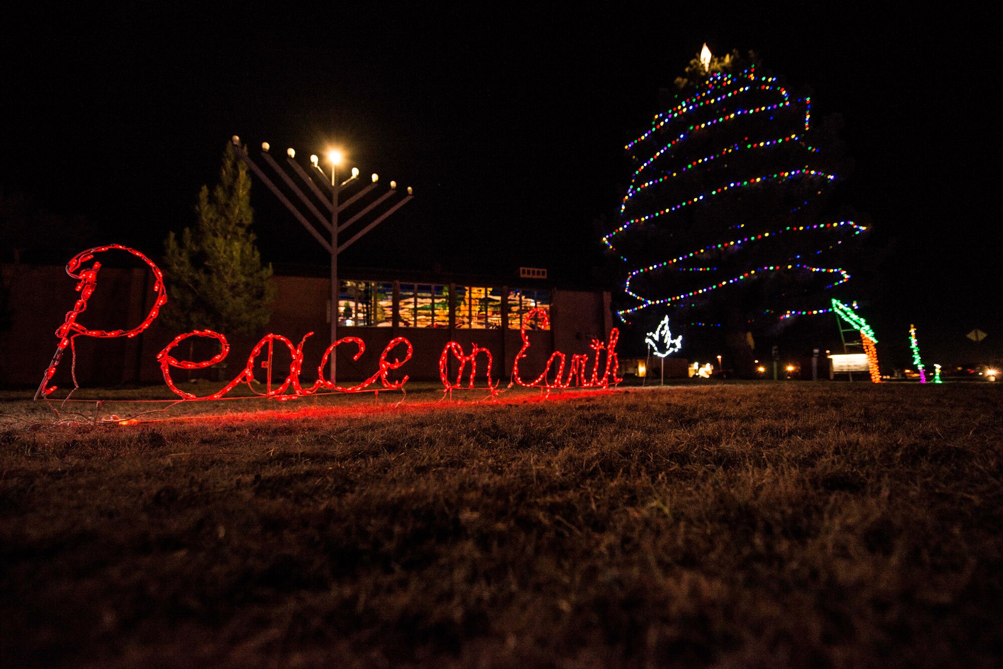 Holiday decorations glow in front of the Holloman Chapel following the Lighting of the Christmas Tree and Menorah Ceremony on Dec. 1. Santa made an appearance on a fire truck and children sang holiday-themed songs during the ceremony. (U.S. Air Force photo by Airman 1st Class Randahl J. Jenson) 