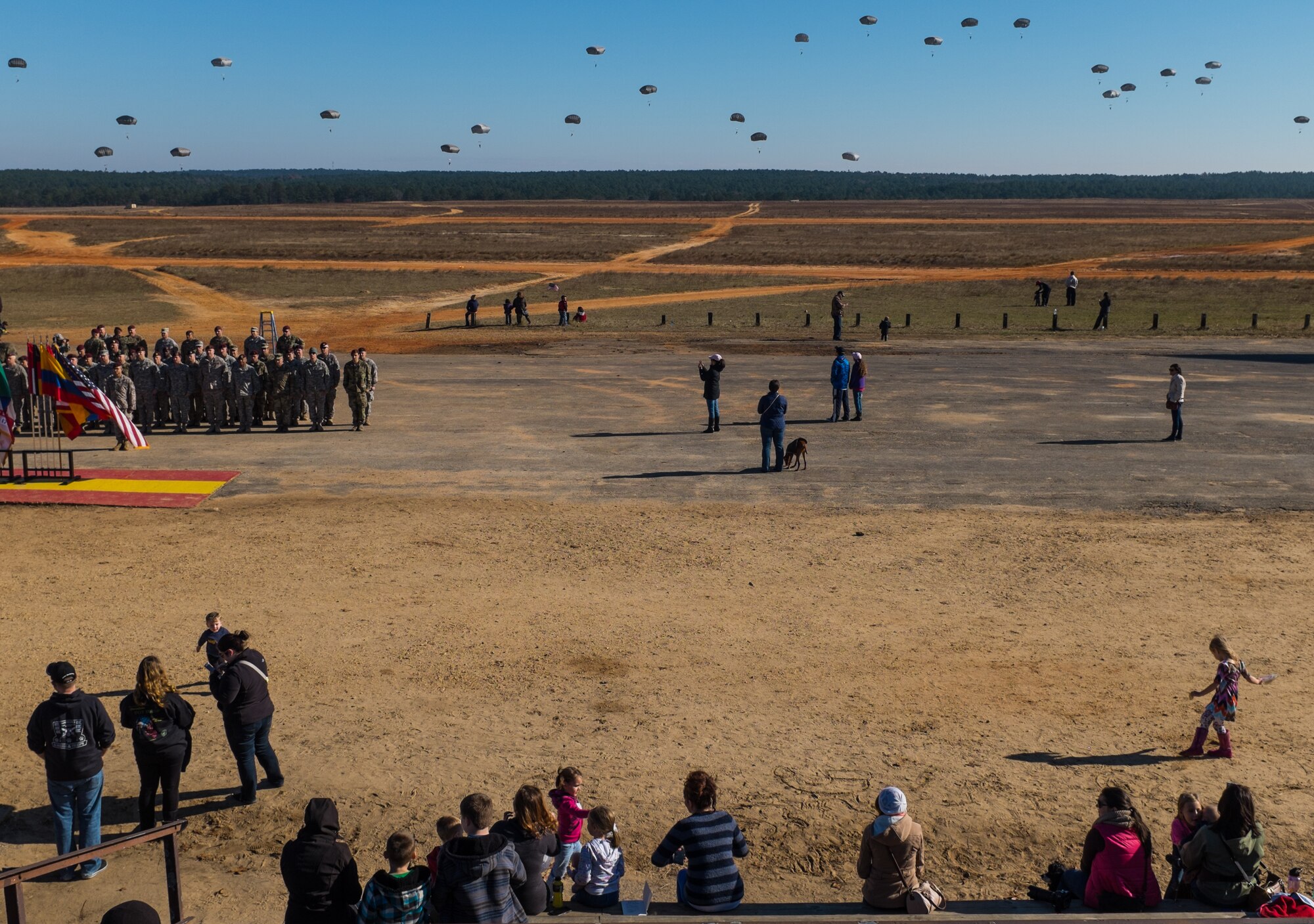 U.S. Army paratroopers fill the sky at Sicily Drop Zone as friends and families watch during the 18th Annual Randy Oler Memorial Operation Toy Drop, hosted by U.S. Army Civil Affairs & Psychological Operations Command (Airborne), Dec. 5, 2015, at Fort Bragg, N.C. Operation Toy Drop is the world’s largest combined airborne operation and allows Soldiers the opportunity to help children in need everywhere receive toys for the holidays. (U.S. Army photo by Timothy L. Hale)
