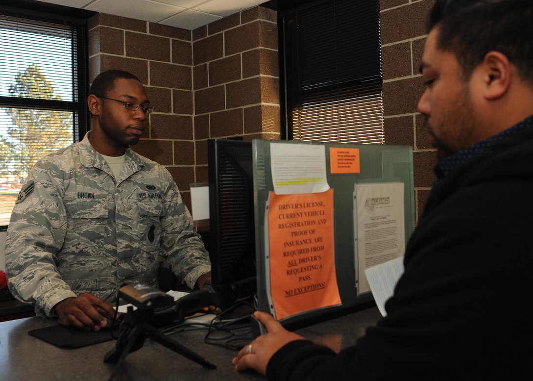 Senior Airman Richard Brown, 28th Security Forces Squadron visitor control center clerk, assists Justin Lata, a student at South Dakota School of Mines and Technology, with a visitor’s pass at Ellsworth Air Force Base, S.D., Nov. 10, 2015. During an average week, the VCC issues approximately 150 paper passes and 80 Department of Defense identification cards. (U.S. Air Force photo by Airman Sadie Colbert/Released)