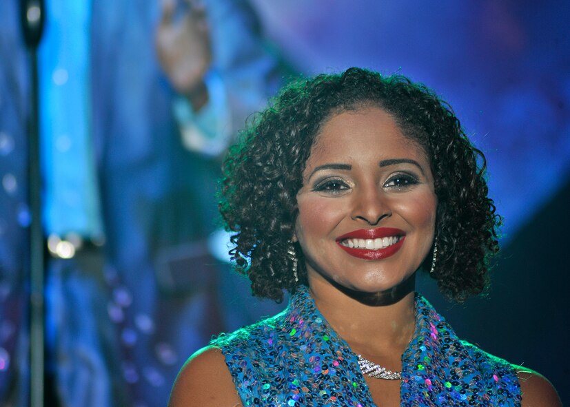 2nd Lt. Nicque Robinson, 319th Contracting Flight contracting specialist, smiles to a crowd during a Tops in Blue performance at the Chester Fritz Auditorium on the University of North Dakota campus, Dec. 2, 2015, in Grand Forks, North Dakota. Robinson was selected as a female vocalist and stage director for the 2015 Tops in Blue performance tour. (U.S. Air Force photo by Senior Airman Xavier Navarro/Released)