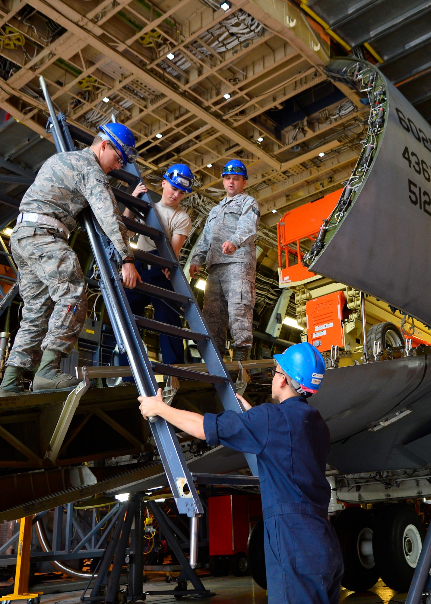 Tech. Sgt. Kevin Taylor, 436th Maintenance Squadron isochronal dock floor chief, oversees as Airmen remove the flight deck access ladder from a C-5M Super Galaxy during a Maintenance Steering Group-3 Major inspection Dec. 2, 2015, at Dover Air Force Base, Del. The ladder was being removed so maintainers could make repairs to the ladder’s guide tracks. (U.S. Air Force photo/Senior Airman William Johnson)