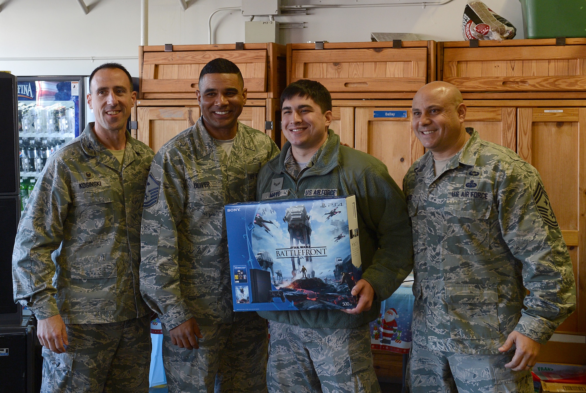 Col. Leonard Kosinski (from left to right), 62nd Airlift Wing commander, Master Sgt. Calvin Oliver, 62nd Operations Support Squadron first sergeant, Airman 1st Class Edward Mayo,  62nd OSS air traffic controler, and Chief Master Sgt. Zaki Mazid, 62nd Airlift Wing command chief, pose for a picture Dec. 4, 2015, during Team McChord’s Single Airmen’s Feast at Joint Base Lewis-McChord, Wash. Mayo was the winner of the “simon says” formation drill competition and received the grand prize for the Playstation 4. (U.S. Air Force photo/Senior Airman Divine Cox)