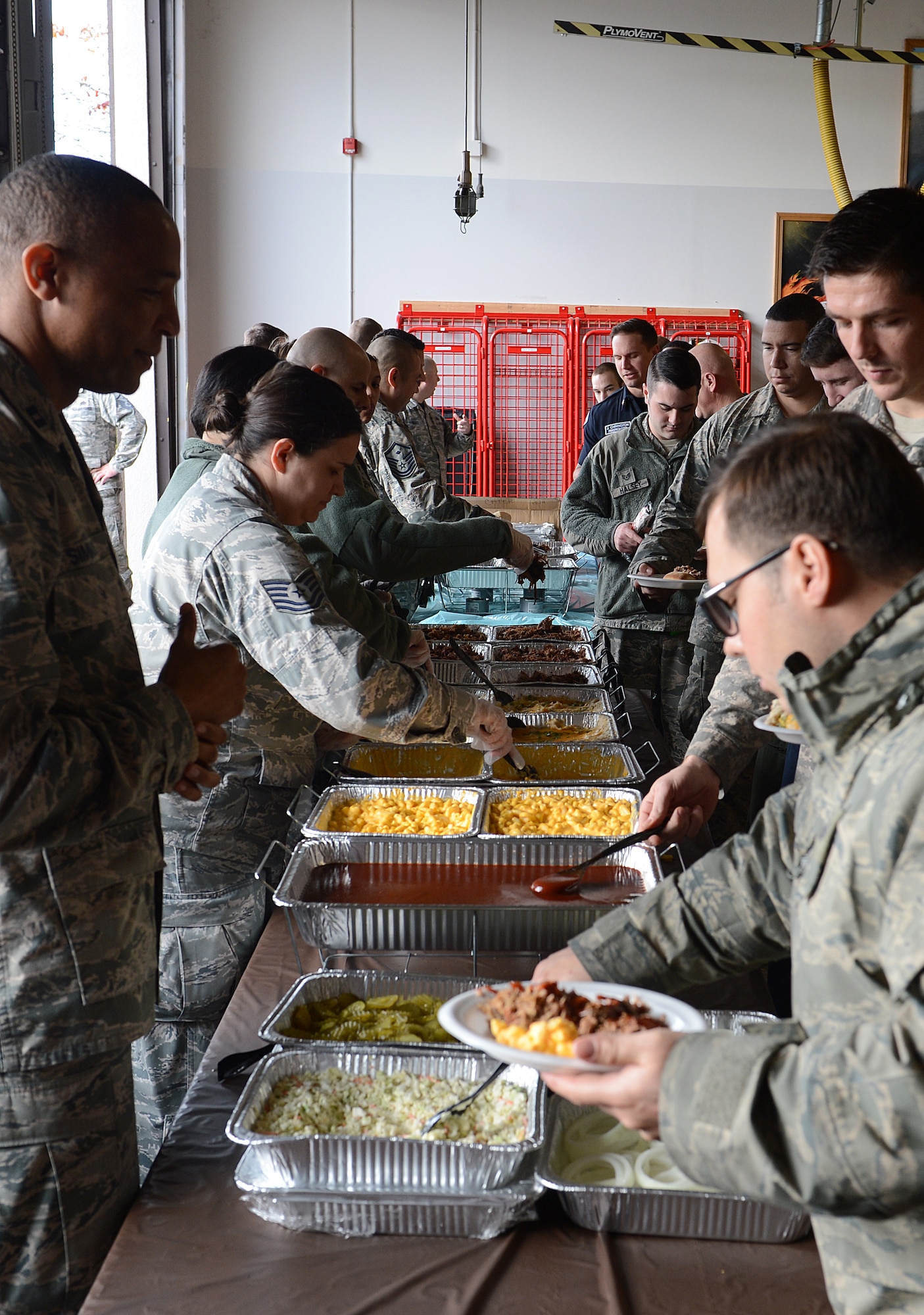 McChord Field volunteers serve Airmen food Dec. 4, 2015 during Team McChord’s Single Airmen’s Feast at Joint Base Lewis-McChord, Wash. Airmen were served pulled pork, smoked brisket, mashed potatoes, macaroni and cheese and rolls before the raffle for prizes began. (U.S. Air Force photo/Senior Airman Divine Cox)