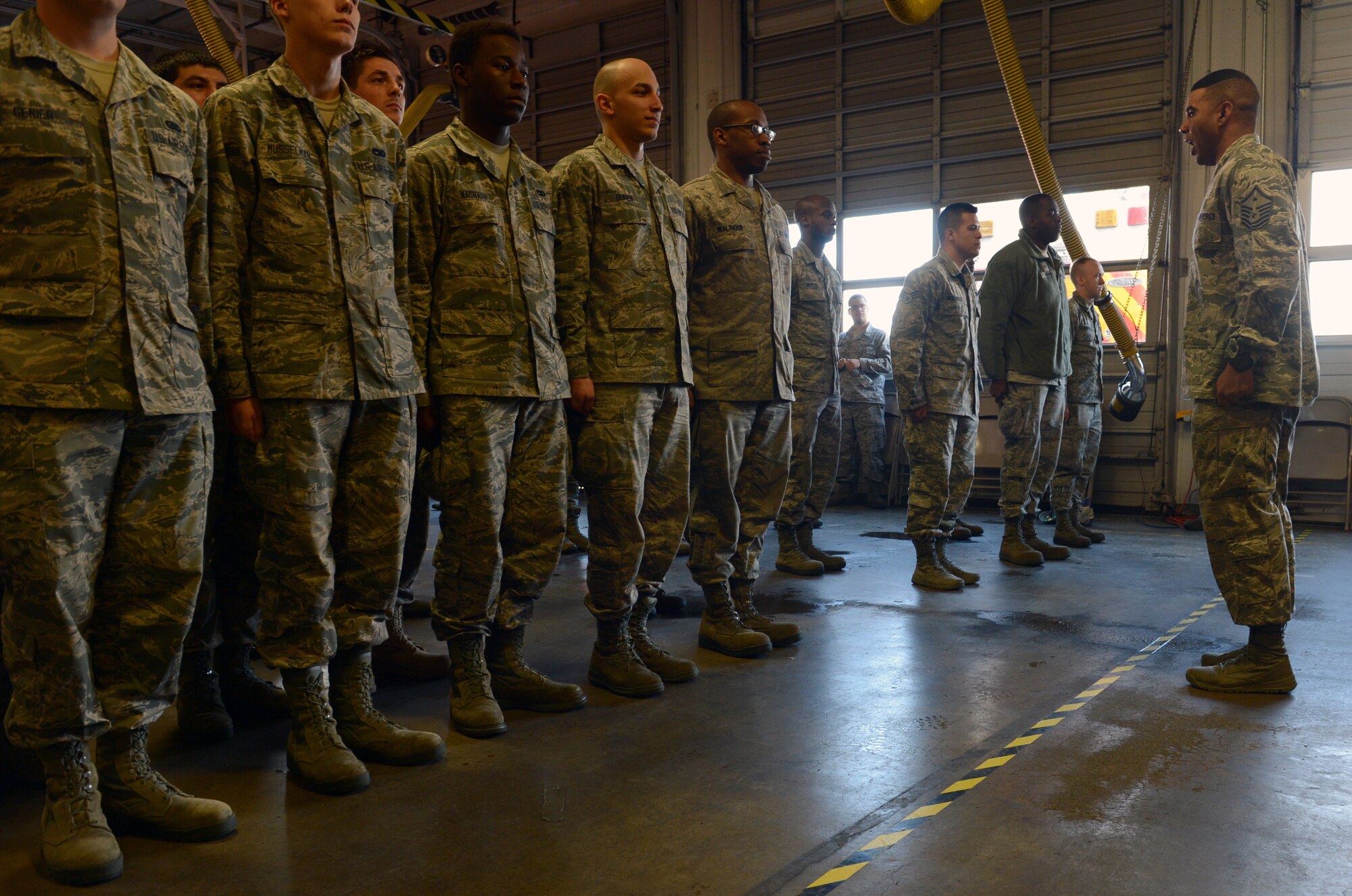 Master Sgt. Calvin Oliver, 62nd Operations Support Squadron first sergeant, forms a group of Airmen into a formation as they compete for a PlayStation 4, Dec. 4, 2015, during Team McChord’s Single Airmen’s Feast at Joint Base Lewis-McChord, Wash. Oliver gave drill commands for the Airmen to follow until all but one Airman was disqualified, winning the grand prize. (U.S. Air Force photo/Senior Airman Divine Cox)