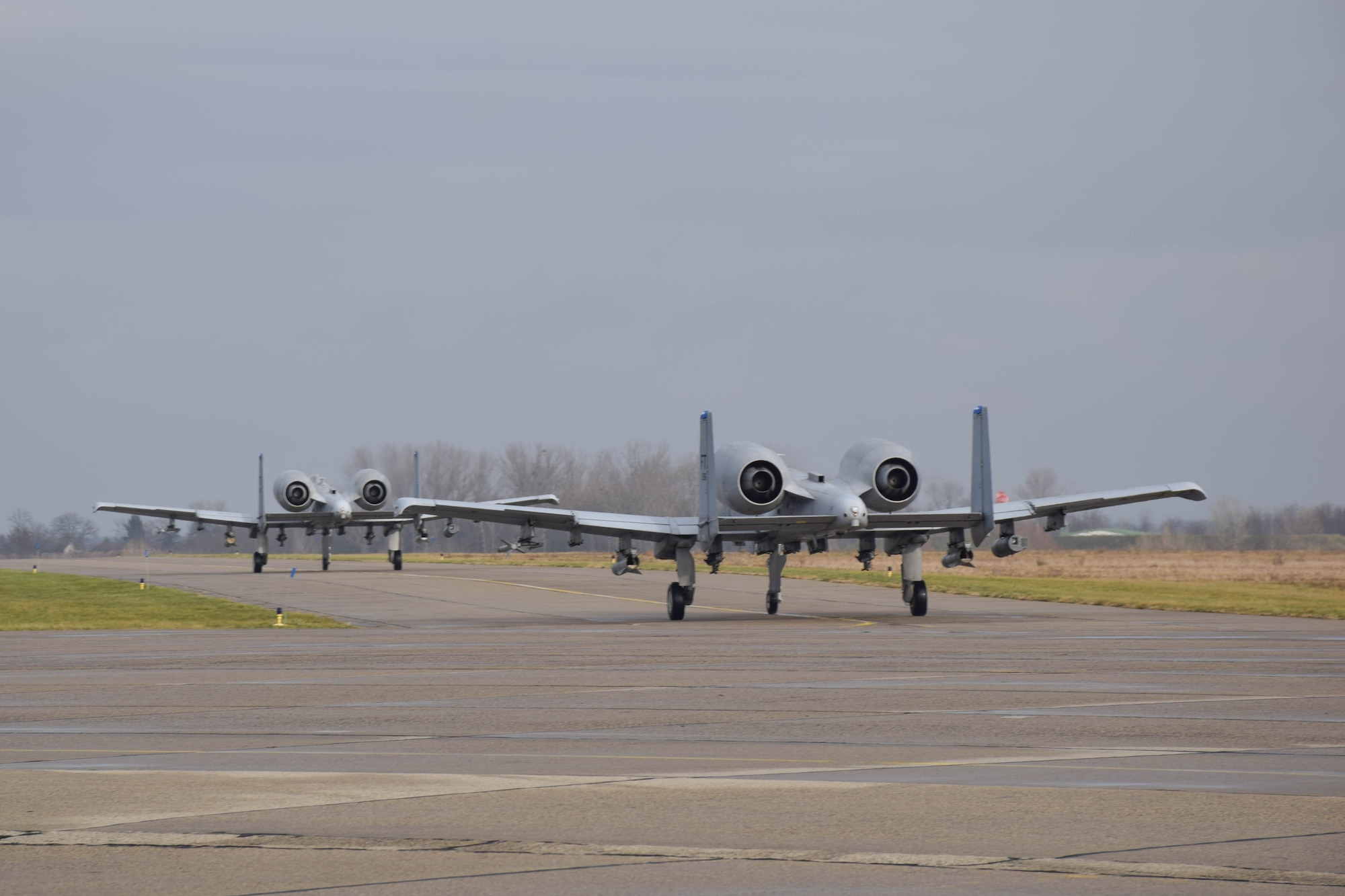Two A-10C Thunderbolt IIs from the 74th Expeditionary Fighter Squadron taxi at Papa Air Base, Hungary, Dec. 2, where they are currently on a micro-deployment as part of a Theater Security Package. The purpose of the deployment is to conduct training and exercises alongside the Hungarian Air Force to increase readiness and enhance interoperability. (U.S. Air Force photo/ Capt. Lauren Ott)