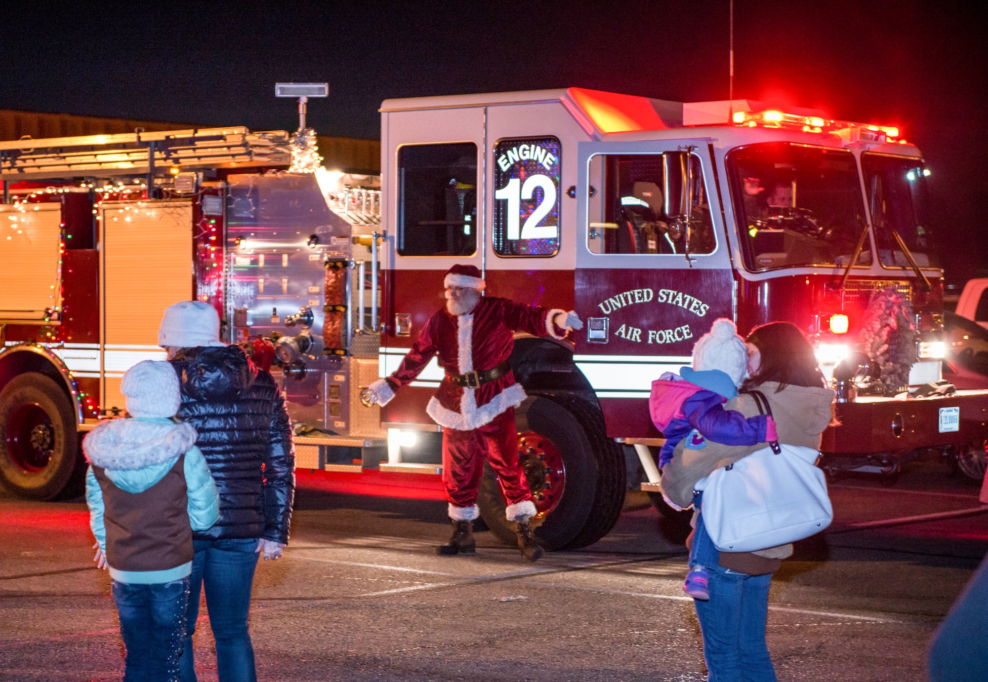 Santa arrives at the Northern Lights Chapel via a decorated firetruck during the annual tree lighting ceremony at Minot Air Force Base, N.D., Dec. 2, 2015. The event offered an opportunity for Airmen and their families to enjoy the holidays together. (U.S. Air Force photo/Airman 1st Class J.T. Armstrong)