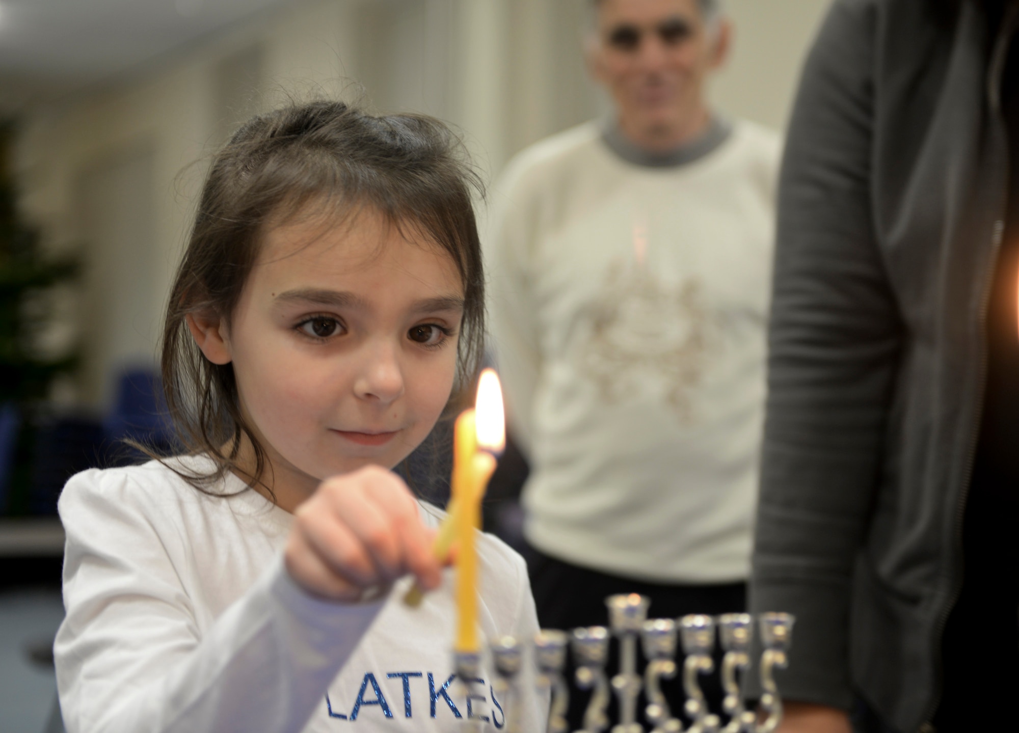 A child lights a menorah Dec. 6, 2015, in the base chapel on RAF Mildenhall, England. The event celebrated the Jewish holiday of Hanukkah at RAF Mildenhall. (U.S. Air Force photo by Staff Sgt. Micaiah Anthony/Released) 